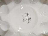 a close up of a white porcelain bowl with writing on it