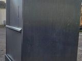 an image of a metal refrigerator on wheels in a parking lot