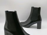 des bottines en cuir noir sur fond blanc