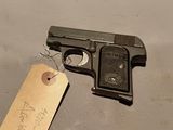 un petit pistolet muni d'une étiquette, posé sur une table