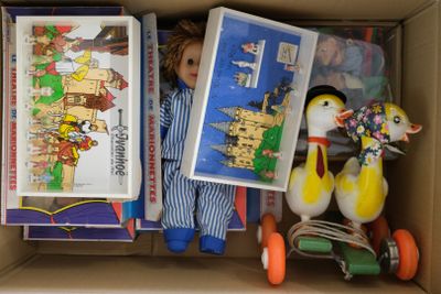 une boîte remplie de jouets, avec une poupée dedans