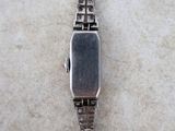 an image of a silver watch with a black cord around it