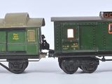 two toy trains sitting side by side on a white surface
