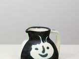 un vase noir et blanc sur lequel est peint un smiley
