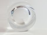 a clear glass vase with a silver lid on a white surface