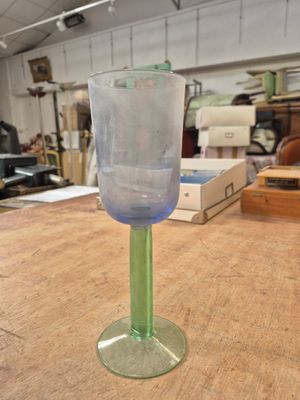 un verre à vin vert posé sur une table en bois