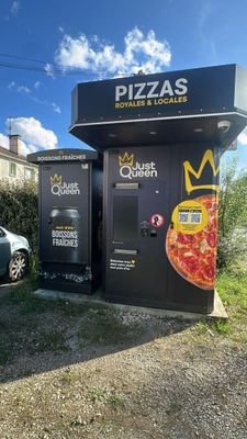a pizza machine that is next to a parking lot