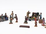a group of figurines of people sitting on a bench