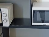 un micro-ondes et un four à micro-ondes posés sur une étagère