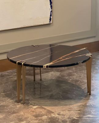 a black and gold coffee table on a marble floor