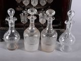 bottles and glasses are lined up on a table in front of a wooden case