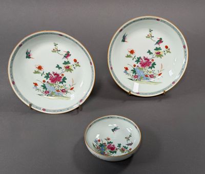 trois assiettes en porcelaine et un bol posés sur une table