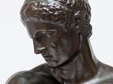 statue of a young man with his hands on his chest