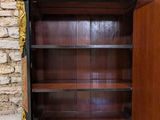 a black and gold painted bookcase with a door open