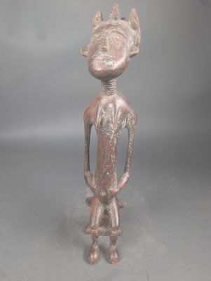 une vieille figurine en bronze représentant un homme avec un oiseau sur la tête