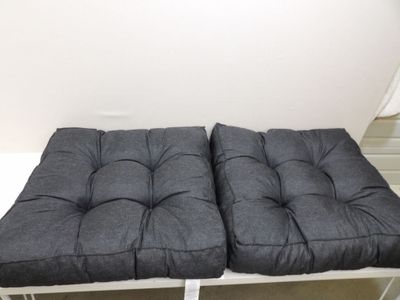 pair of grey cushions on a white bench in a white room