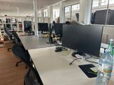 un bureau d'ordinateur sur lequel se trouvent deux écrans et une bouteille d'eau