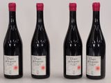 four bottles of wine are lined up on a white surface