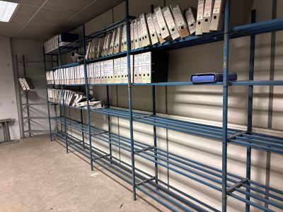 une étagère remplie de classeurs, dans une pièce