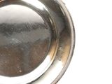 une assiette en argent posée sur une table, sur fond blanc
