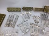 a lot of silverware on a table with silverware in it