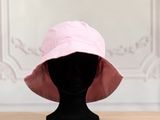 pink bucket hat on a mannequin head on a wooden table
