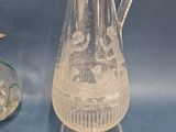 a glass pitcher and a glass vase on a blue surface