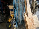 Plusieurs panneaux de contreplaqué sont empilés dans un garage