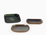trois petites assiettes rectangulaires recouvertes d'un émail noir et marron
