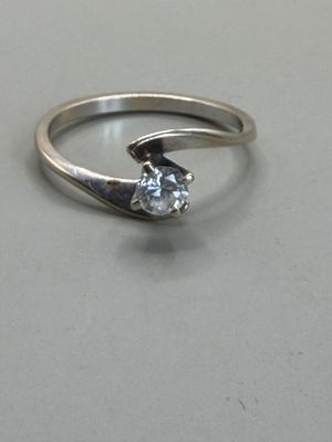 a silver ring with a diamond in it on a table