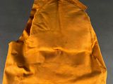 an overhead view of a yellow bag with a brown handle