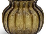 vase en verre jaune orné d'un motif ondulé sur fond blanc
