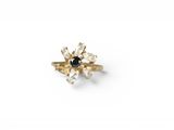 a close up of a gold ring with a black and white diamond