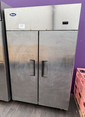 two stainless steel refrigerators sitting next to each other in a room