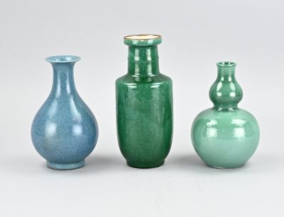 trois vases posés l'un à côté de l'autre sur une surface blanche