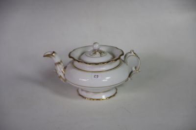 une théière blanche ornée d'une bordure dorée