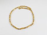 un bracelet en or sur une surface blanche