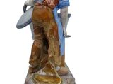 figurine of a man with a guitar and a hat on a pedestal