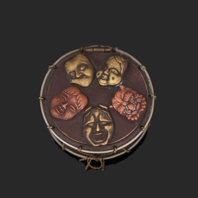 a small round box with five different faces on it