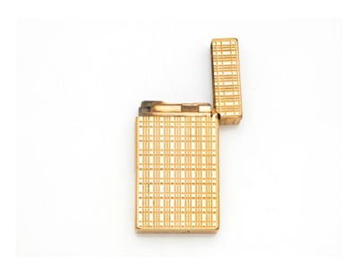 un briquet doré posé sur une surface blanche