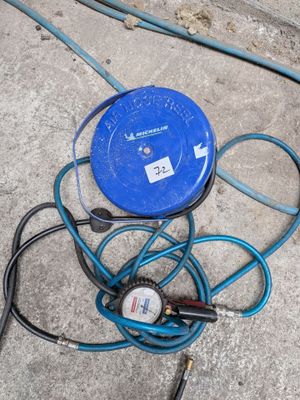 un tuyau bleu et un compresseur bleu posés par terre