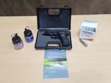 un pistolet posé sur une table à côté d'une bouteille d'eau
