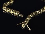 gold chain bracelet on a black background with a diamond clasp