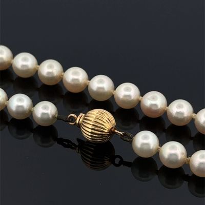 gros plan d'un collier de perles sur une surface noire