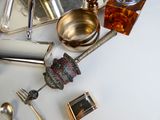 de nombreux objets en argent posés sur une table, avec des cuillères et des couverts