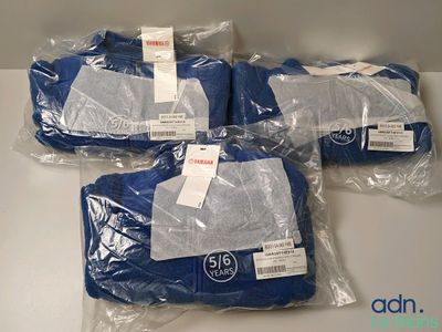 quatre serviettes bleues emballées dans des sacs en plastique, posées sur une table