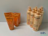 four bottles of sunscreen lotion sitting on a table next to a tube of sunscreen lotion