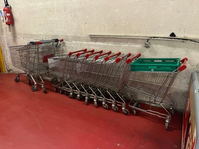 many shopping carts lined up in a row on the floor