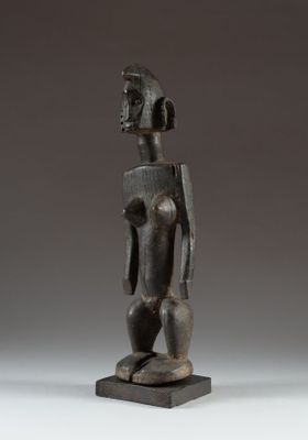 a statue of a man standing on a wooden base