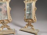 pair of antique gold picture frames with a man ' s face in the middle